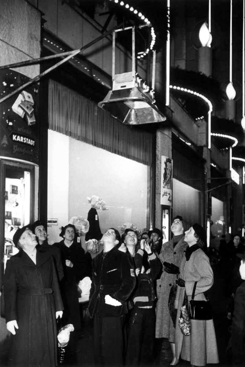 Bezoekers aan de kerstmarkt in Keulen verwonderen zich over de Schwank infraroodverwarmers, jaren 1960.